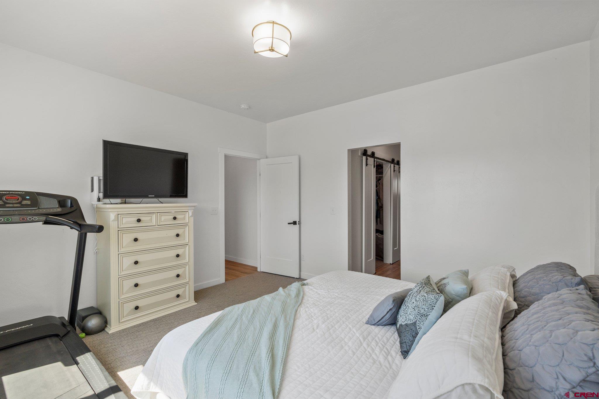 1517 Golf Course Lane Cortez, CO 81321 - Photo 17 of 41 a bedroom with a bed and a flat tv screen on dresser