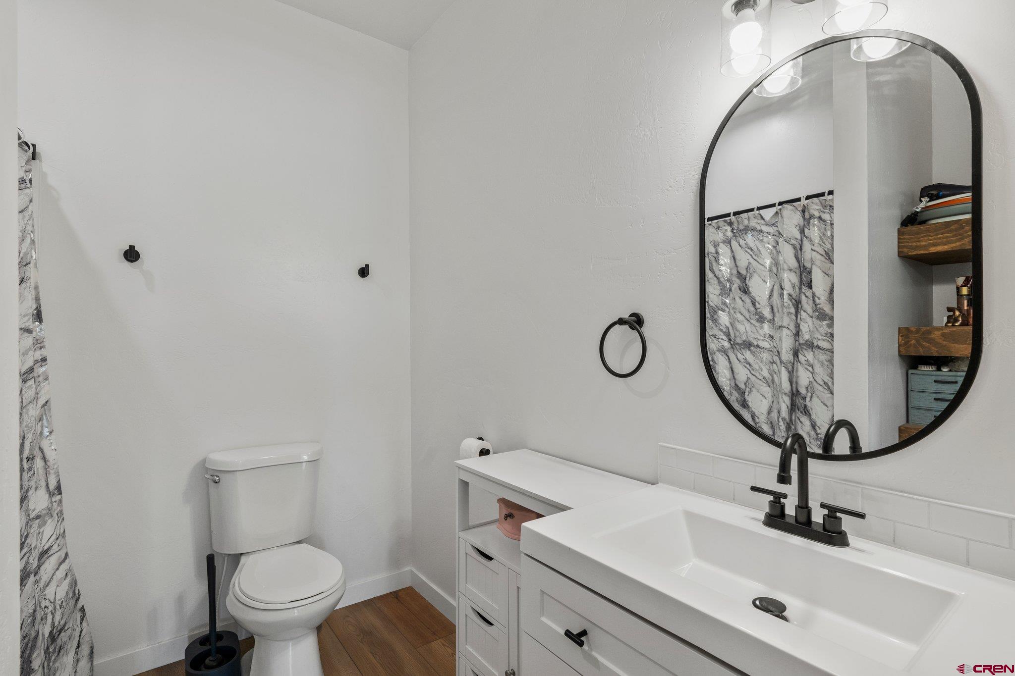 1517 Golf Course Lane Cortez, CO 81321 - Photo 26 of 41 a bathroom with a toilet a sink and mirror