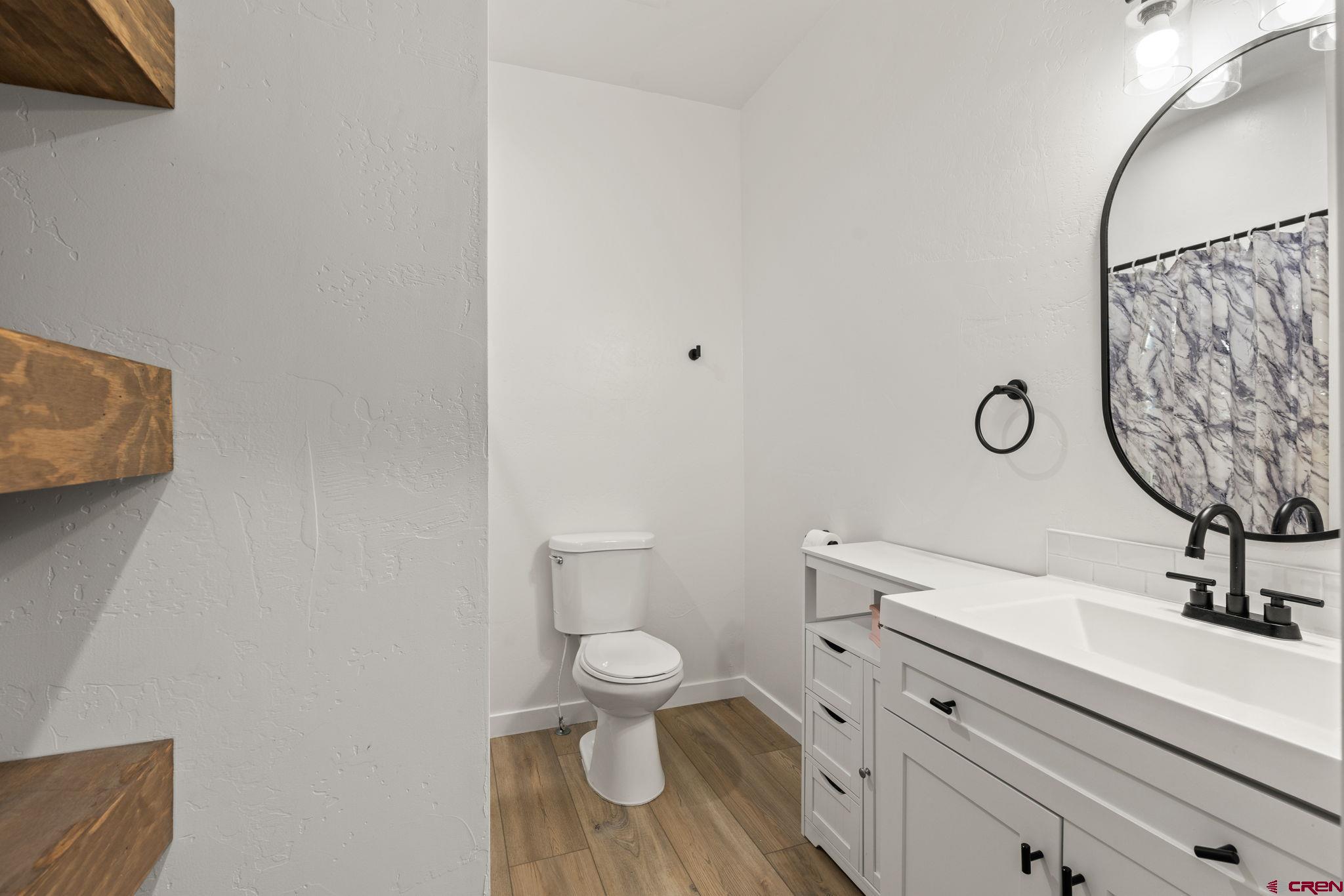1517 Golf Course Lane Cortez, CO 81321 - Photo 27 of 41 a bathroom with a toilet sink and mirror