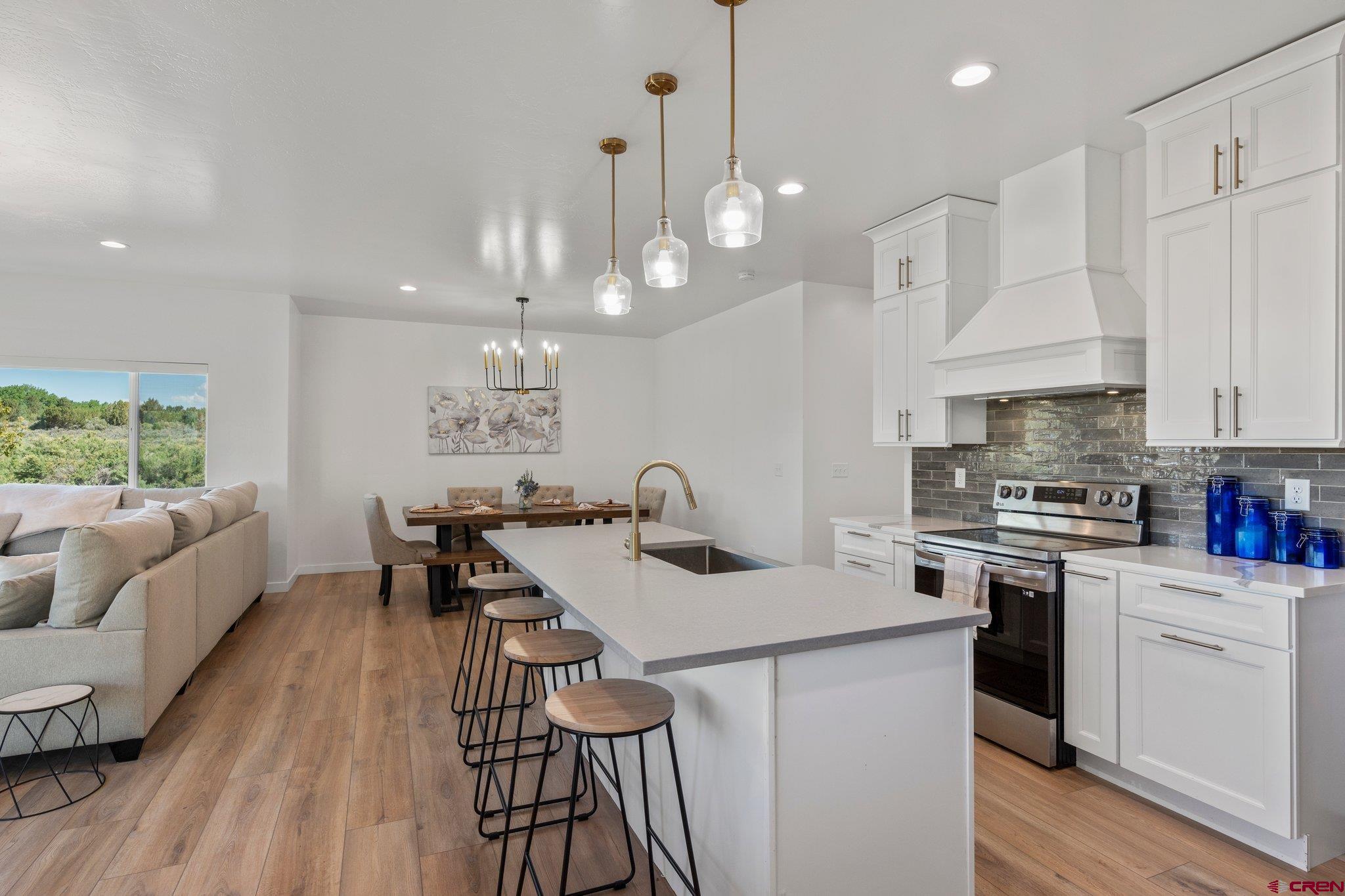 1517 Golf Course Lane Cortez, CO 81321 - Photo 10 of 41 a kitchen with stainless steel appliances a table chairs stove and white cabinets