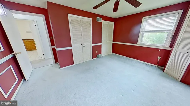 a view of an empty room with window and stairs