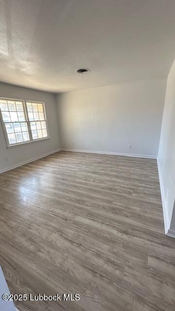 5110 46th Street Lubbock, TX 79414 - Photo 7 of 17 an empty room with wooden floor and windows