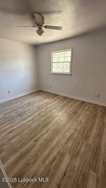 5110 46th Street Lubbock, TX 79414 - Photo 9 of 17 an empty room with wooden floor ceiling fan and windows