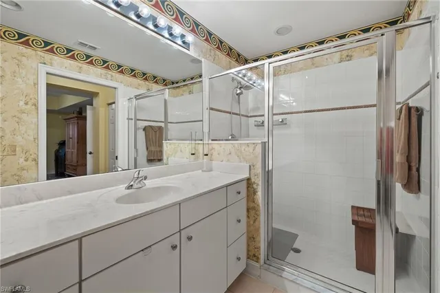 a bathroom with a double vanity sink mirror and shower