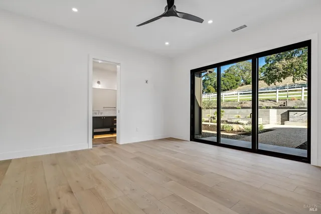 an empty room with sliding door and balcony