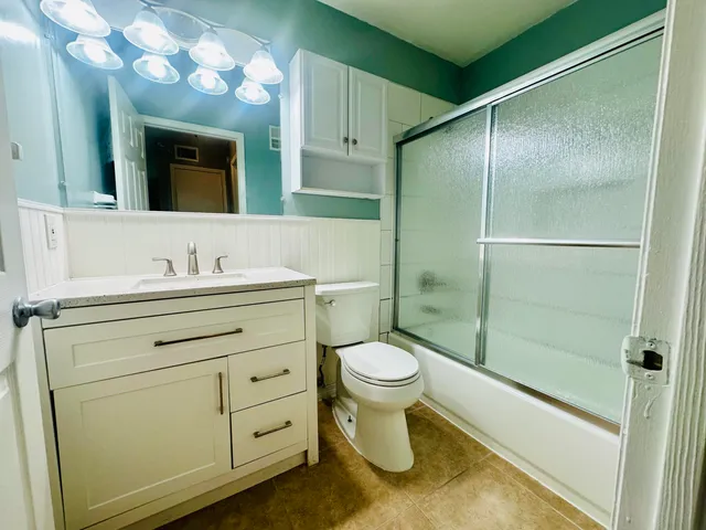 a bathroom with a sink a toilet and shower
