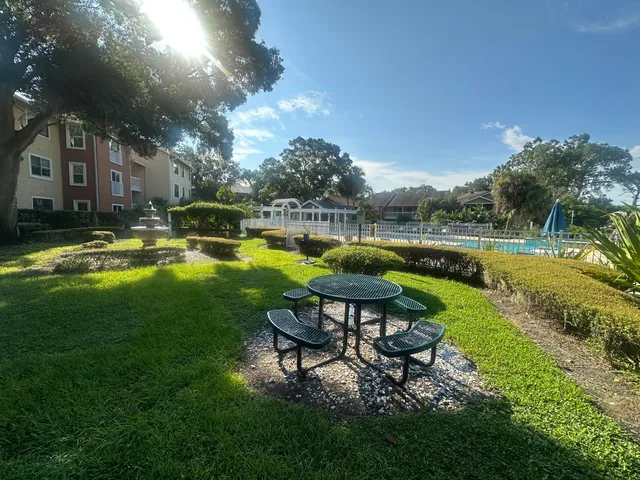 a view of a swimming pool and lounge chairs in back yard of the house