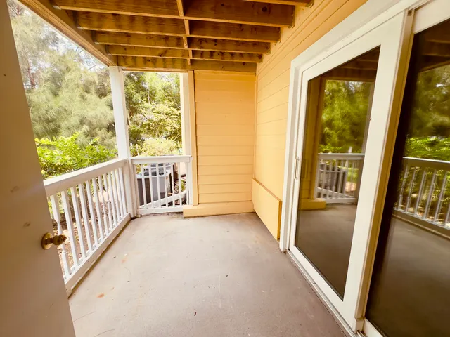 a view of a porch with wooden floor and door
