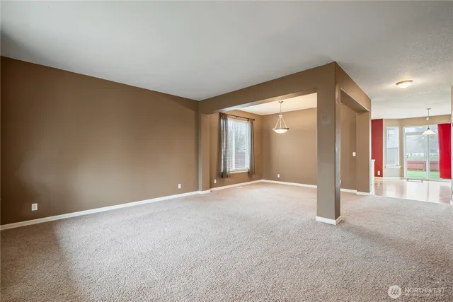 a view of a big room with windows and chandelier fan