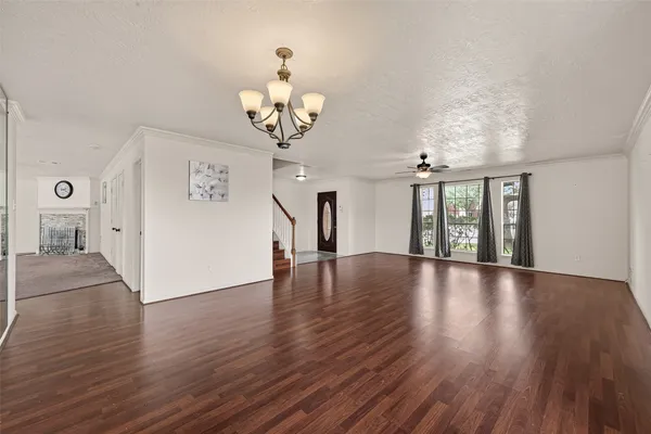 a view of a room with wooden floor and chandelier