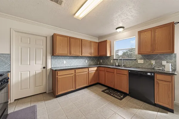 a kitchen with stainless steel appliances granite countertop white cabinets and a stove top oven