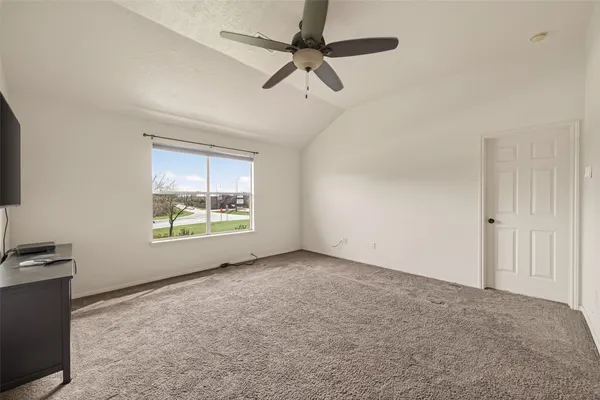 a view of a livingroom with a flat screen tv wooden floor and a ceiling fan