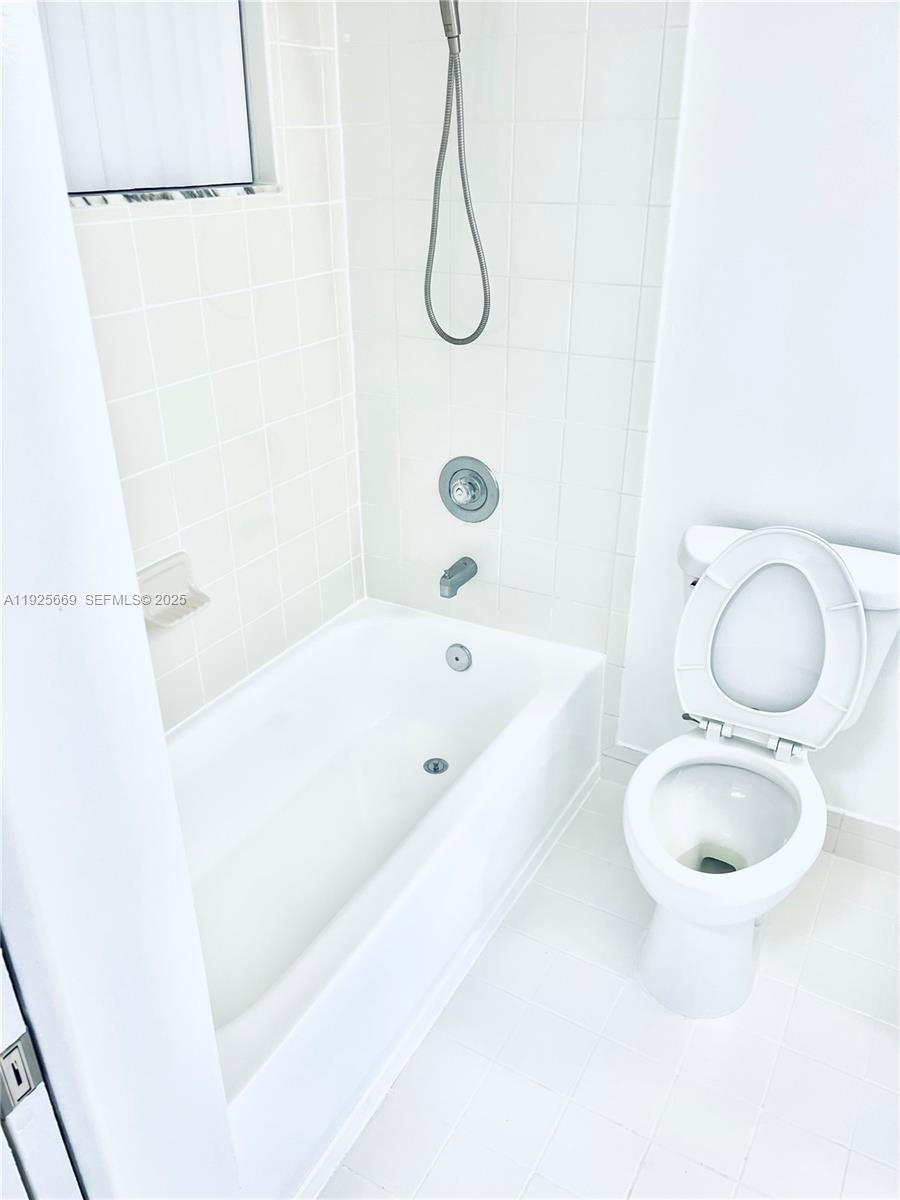6801 Harding Avenue, Unit 306 Miami Beach, FL 33141 - Photo 12 of 30 a bathroom with a granite countertop sink a toilet and bathtub