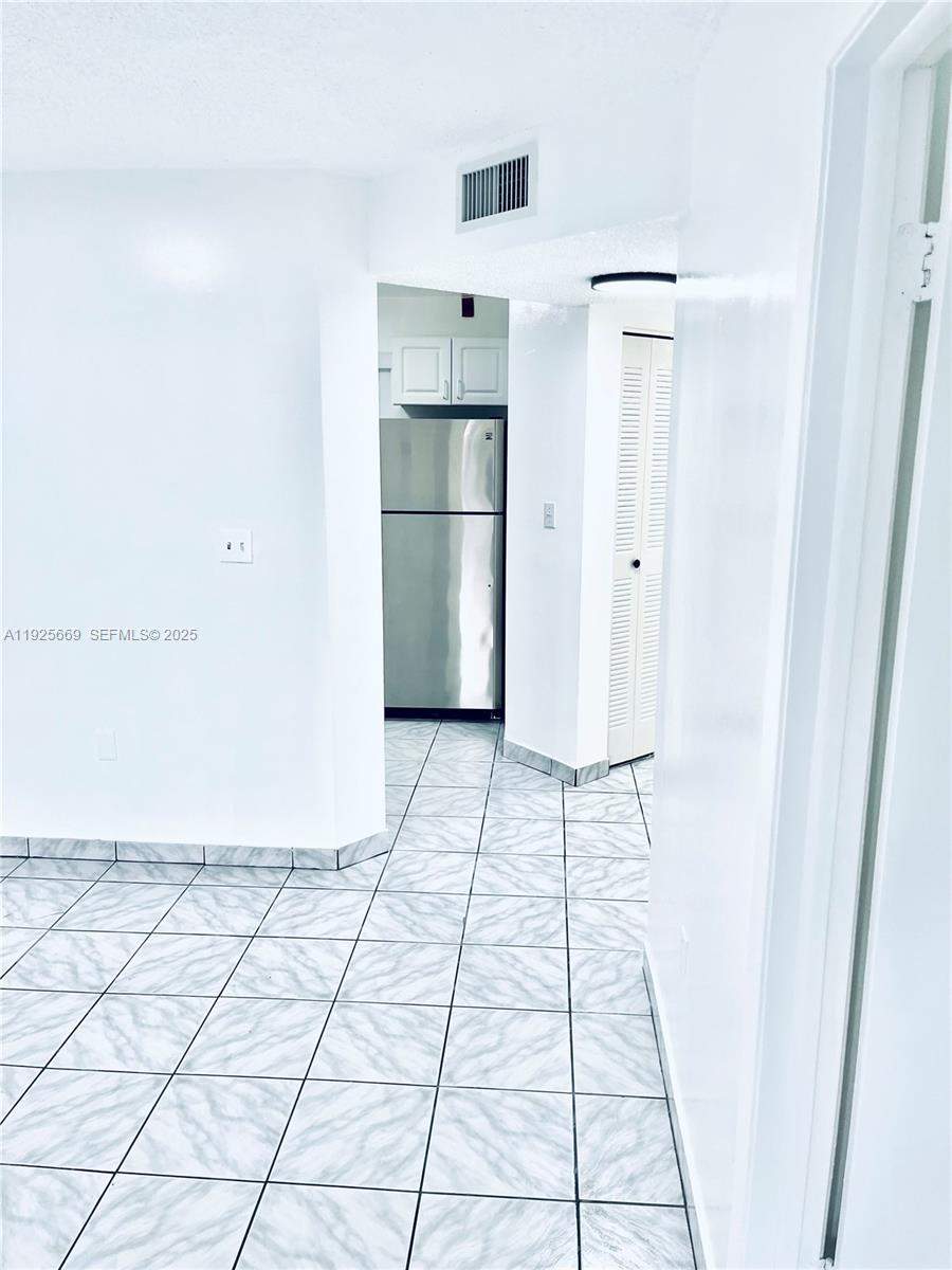 6801 Harding Avenue, Unit 306 Miami Beach, FL 33141 - Photo 18 of 30 a view of a refrigerator in kitchen and an empty room