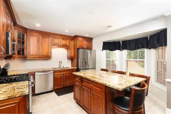 a kitchen with stainless steel appliances granite countertop sink stove top oven and cabinets