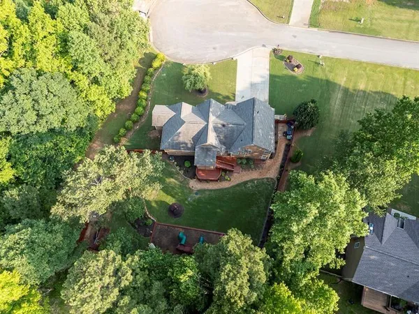 a view of a backyard with couches plants and large tree