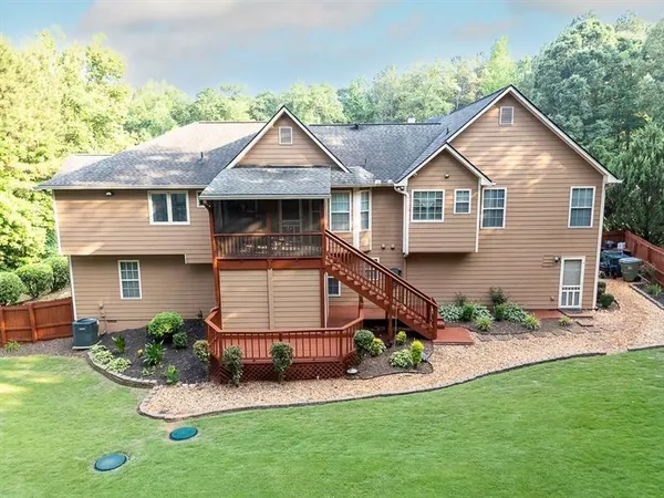 a view of a house with a big yard plants and large trees