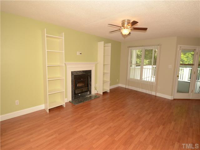 1328 Princess Anne Road Cary, NC 27513 - Photo 4 of 20 a view of an empty room with a fireplace and a window