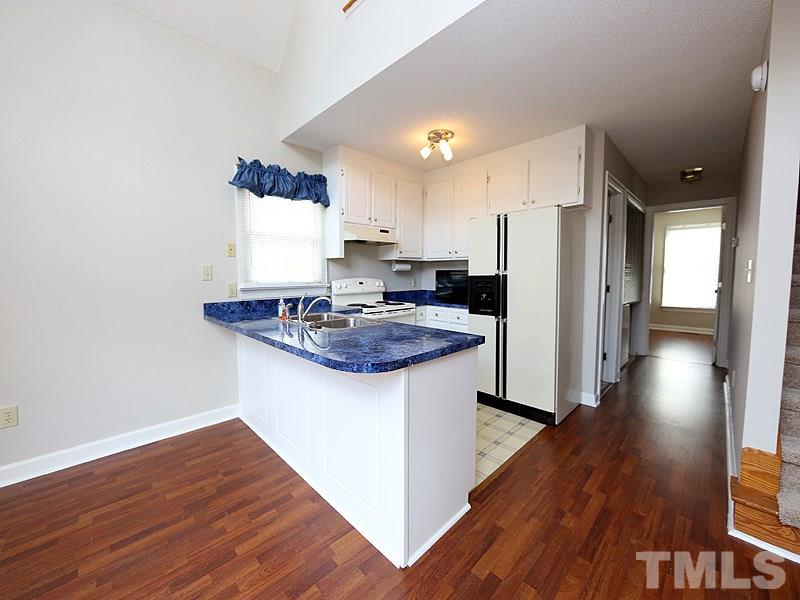 4791 Thomas Road Henderson, NC 27537 - Photo 11 of 25 a kitchen with stainless steel appliances granite countertop a refrigerator a sink dishwasher a stove and white countertops with wooden floor
