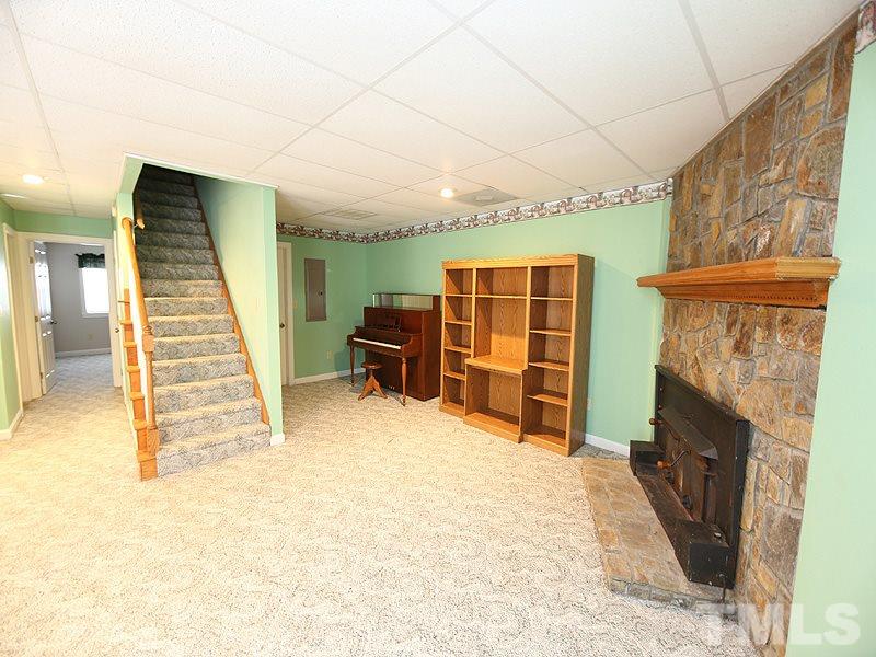 4791 Thomas Road Henderson, NC 27537 - Photo 21 of 25 a view of an empty room with stairs and a fireplace