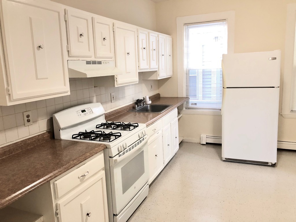 a kitchen with a white cabinets and white appliances