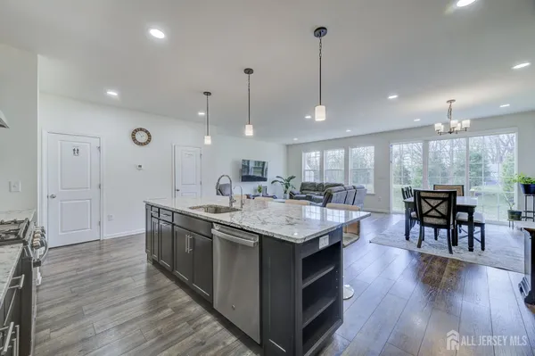 a kitchen with stainless steel appliances granite countertop wooden floors and white cabinets