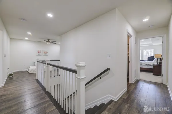 a view of a hallway with wooden floor and stairs