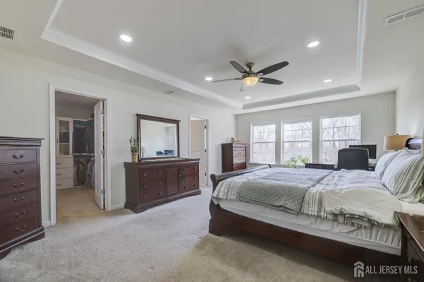 a spacious bedroom with a bed and a dresser