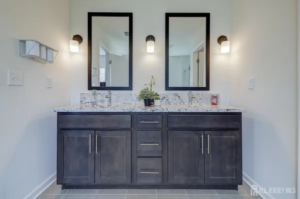 a bathroom with a granite countertop sink vanity and mirror