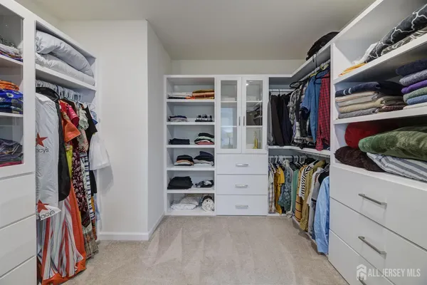 a view of walk in closet with clothes and shoes