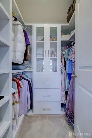 a view of walk in closet with clothes and shoes