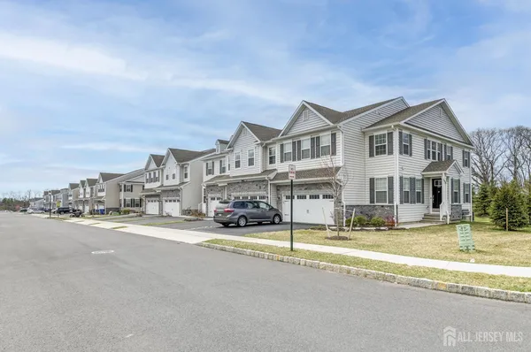 a view of a building with a big yard and large trees