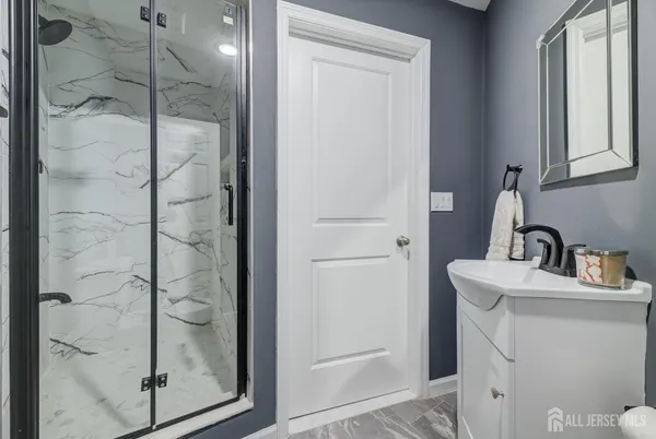 a bathroom with a shower a mirror and a sink