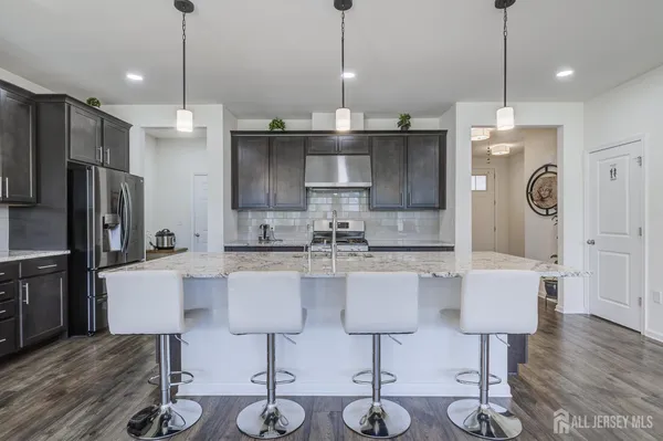a kitchen with stainless steel appliances granite countertop a kitchen island a stove a table and chairs in it