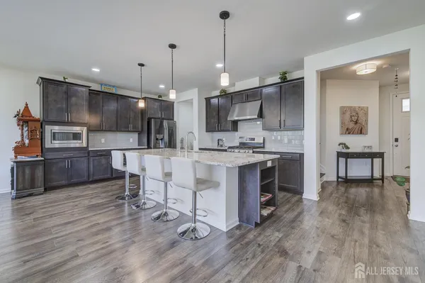 a kitchen with kitchen island granite countertop a sink cabinets and wooden floor