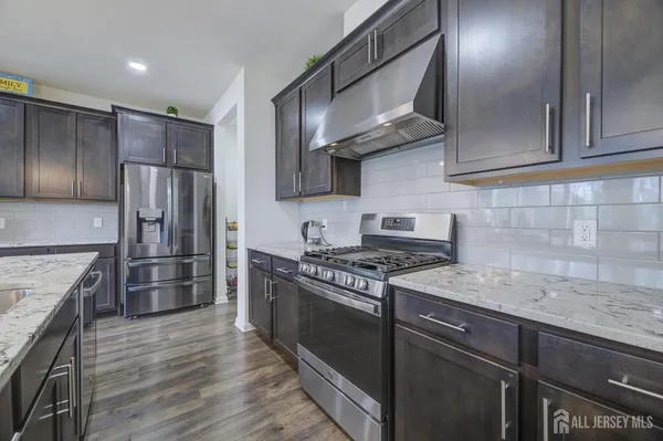 a kitchen with stainless steel appliances granite countertop a sink stove and refrigerator