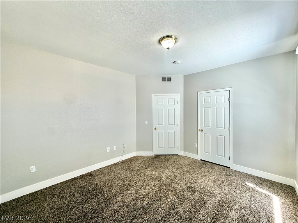 8555 West Russell Road, Unit 2018 Las Vegas, NV 89113 - Photo 21 of 23 A well-proportioned bedroom features soft carpeting and convenient entryways.