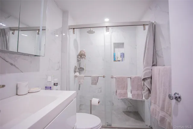 a bathroom with a sink a toilet and shower