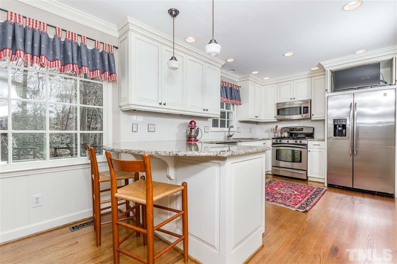 2408 Ridge Road Raleigh, NC 27612 - Photo 10 of 25 a kitchen with stainless steel appliances granite countertop a sink a stove a refrigerator and island with wooden floor
