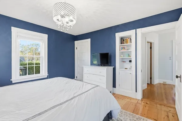 a spacious bedroom with a bed and a television