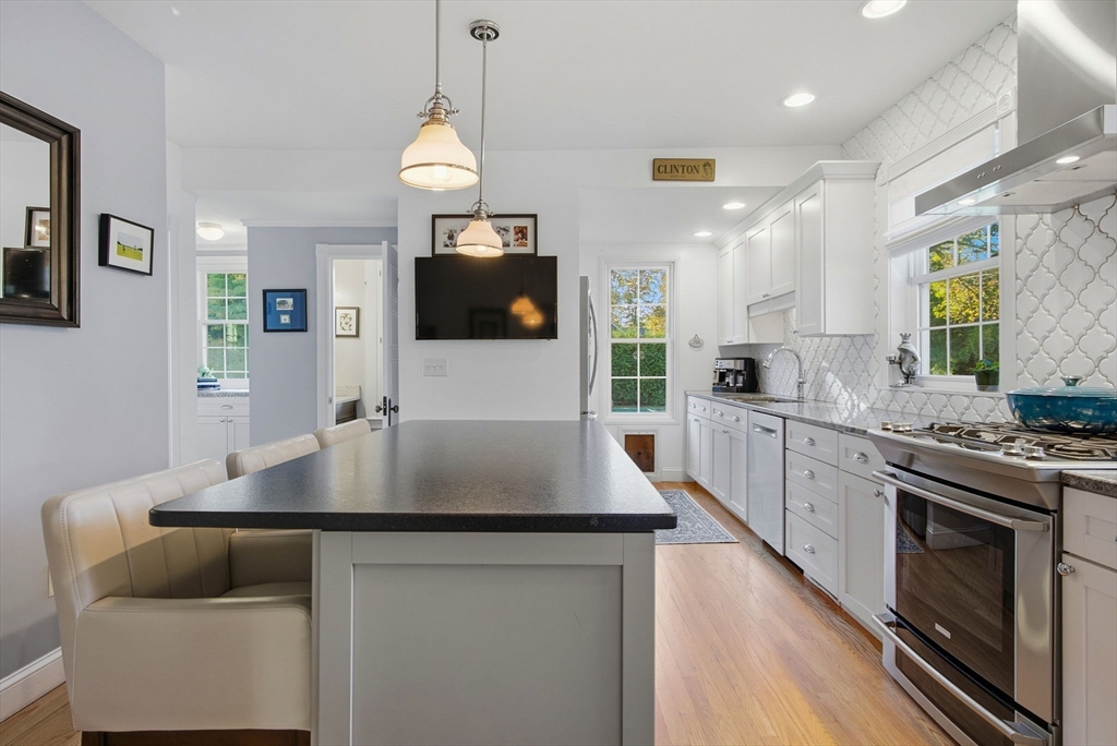 300 Greeley Street Clinton, MA 01510 - Photo 2 of 40 a kitchen with stainless steel appliances granite countertop a stove a sink a microwave a refrigerator white cabinets and couches