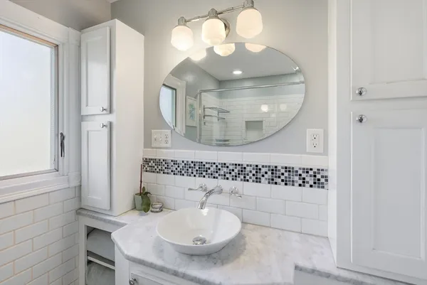 a bathroom with a sink a light fixture and a mirror