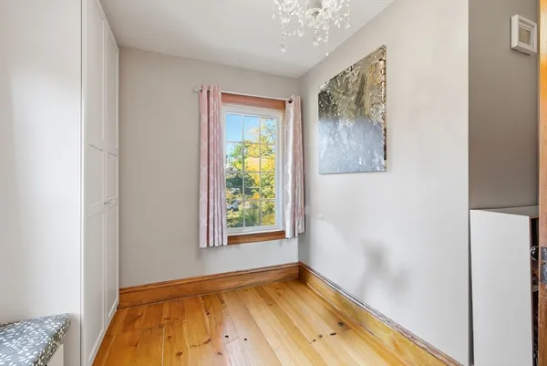 a view of an empty room with window and a bedroom