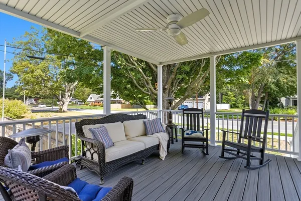 a roof deck with couches and wooden floor