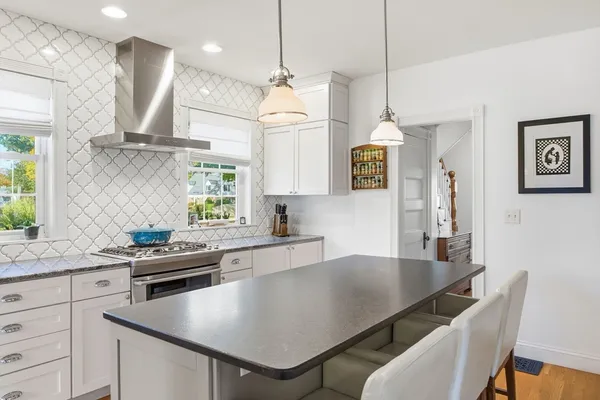 a kitchen with a table chairs microwave and cabinets