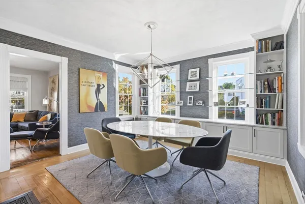 a dining room with furniture a chandelier and wooden floor