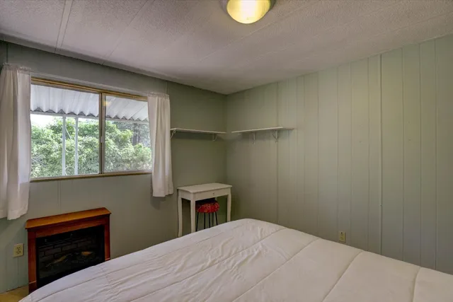 a view of backyard with green space and wooden fence
