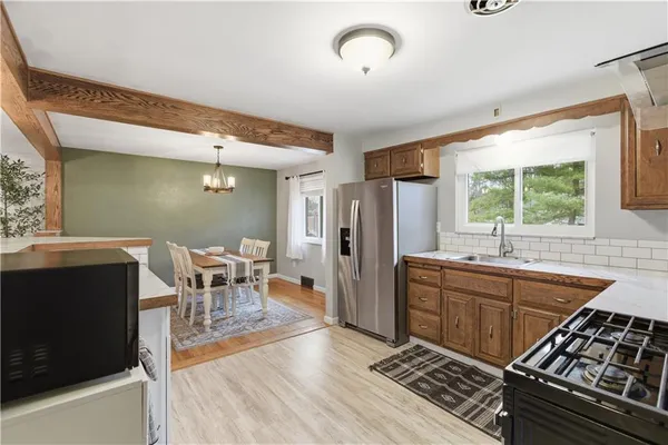 a kitchen with stainless steel appliances granite countertop a stove a sink and a microwave