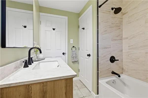 a bathroom with a sink and mirror with bathtub