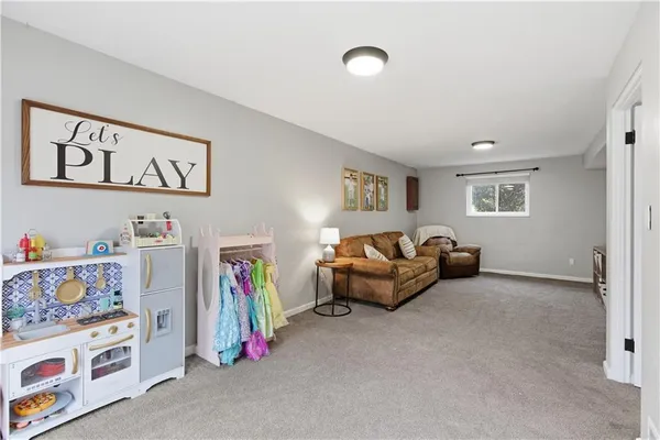 a living room with furniture and a baby crib